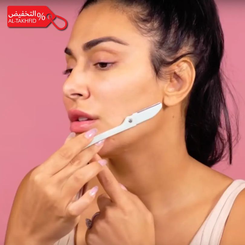 Woman using a Feather Flamingo Facial Razor on her face with a pink background