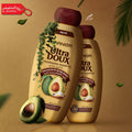 Two bottles of Garnier Ultra Doux shampoo with avocadoes on a brown background