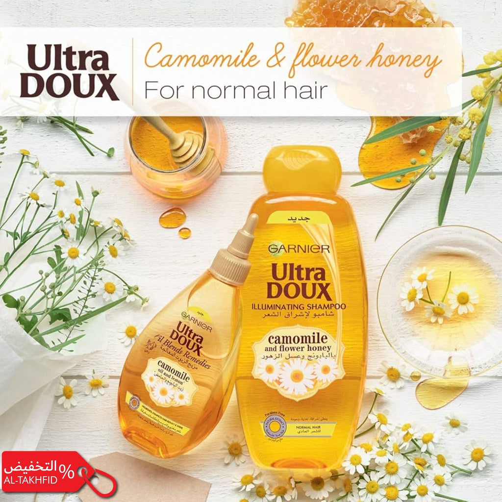 Garnier Ultra DOUX camomile & flower honey shampoo bottle with honey jar and flowers on a white background