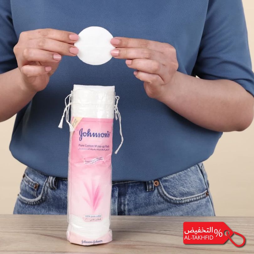 Person holding a Johnson's cotton pad with a pink bottle in the background