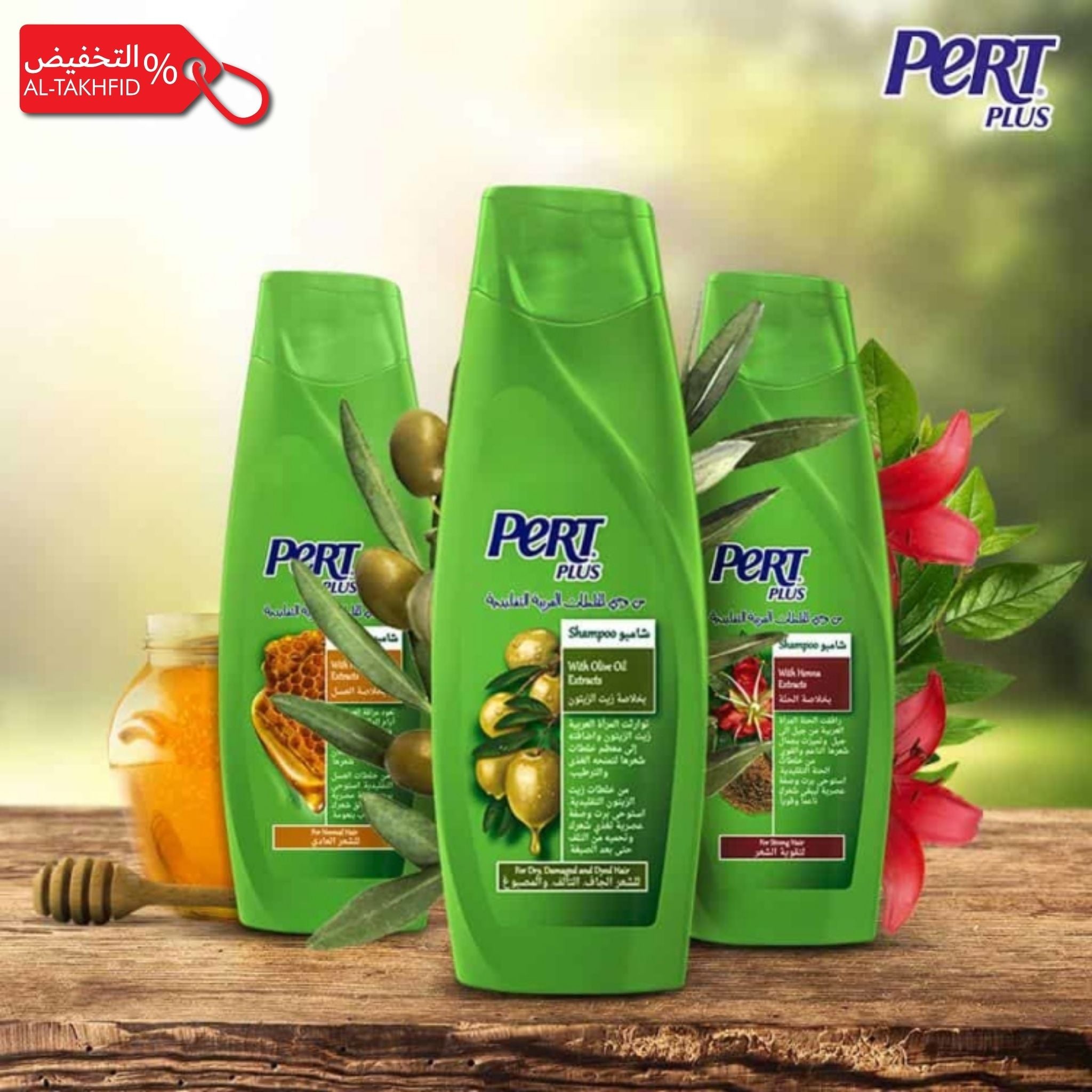 Three green bottles of Pert Plus shampoo on a wooden surface with natural elements and branding visible.