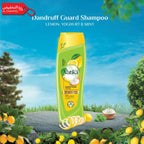 Vatika Dandruff Guard Shampoo bottle with lemon, yogurt, and mint elements against a scenic background.