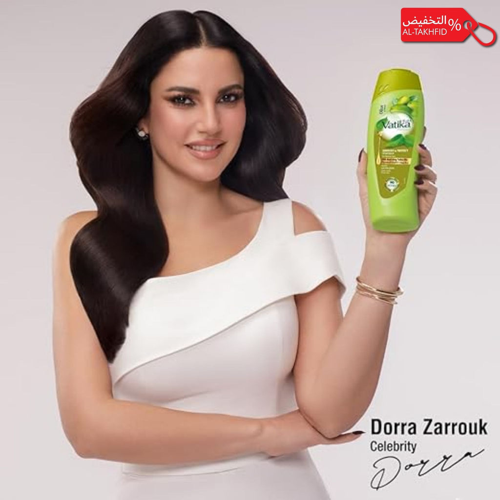 Woman holding a bottle of Vatika hair care product with a white background